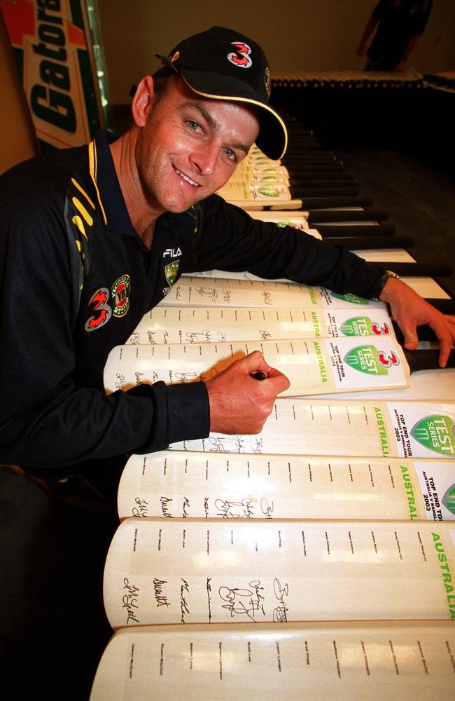 Australian wicket keeper Adam Gilchrist signs a heap of bats before the Darwin Test. Picture: Patrina Malone