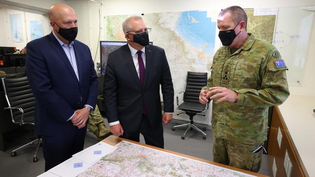 Defence Minister Peter Dutton, left, Scott Morrison and Brigadier Michael Say discuss the flooding at Gallipoli Barracks in Brisbane on Monday. Picture: Getty Images