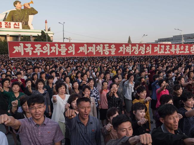 Participants of a mass rally shout slogans as they gather before a banner reading 'let us beat down the sanctions of the imperialists with great progress of self-reliance' on Kim Il-Sung square in Pyongyang. Picture: AFP