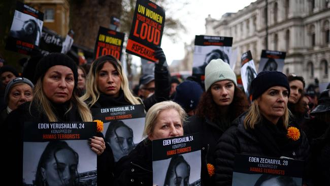 Demonstrators hold posters reading “UN Women, your silence is loud” along pictures of Israeli women being held hostage in Gaza during a rally in London.