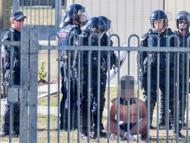 Riot police with an inmate. Picture: Jake Nowakowski