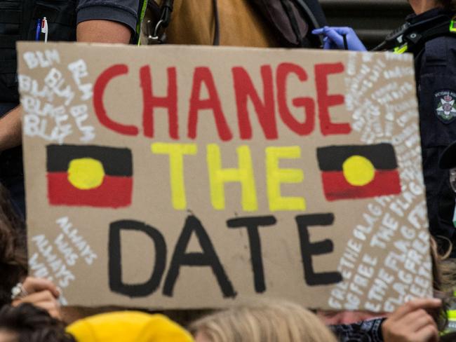 MELBOURNE, AUSTRALIA - JANUARY 26: Police officers stand watch as protesters display signs at the Invasion Day rally in the city on January 26, 2021 in Melbourne, Australia.  Australia Day, formerly known as Foundation Day, is the official national day of Australia and is celebrated annually on January 26 to commemorate the arrival of the First Fleet to Sydney in 1788. Indigenous Australians refer to the day as 'Invasion Day' and there is growing support to change the date to one which can be celebrated by all Australians. (Photo by Darrian Traynor/Getty Images)