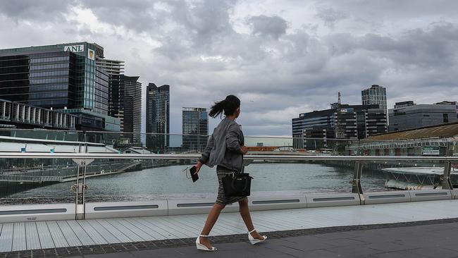 A pedestrian walks over the North Wharf bridge as storm clouds gather this morning. Picture: Ian Currie