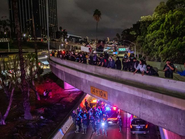 Demonstrators gather on an overpass of the 110 Freeway while police officers gather below in response to the police killing of George Floyd in Los Angeles, California. Picture: Getty