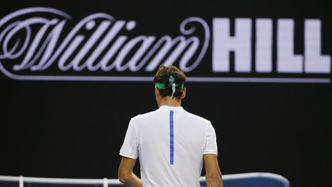 Roger Federer of Switzerland walks to his courtside seat during his first round match against Nikoloz Basilashvili of Georgia at the Australian Open tennis championships in Melbourne, Australia, Monday, Jan. 18, 2016.(AP Photo/Vincent Thian)