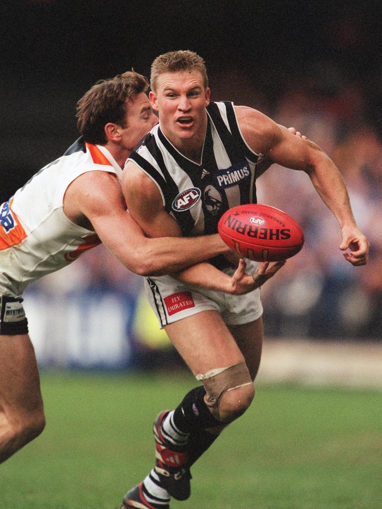 Kangaroos player Corey McKernan tackles Collingwood captain Nathan Buckley at Colonial Stadium in 2000. Picture: George Salpigtidis