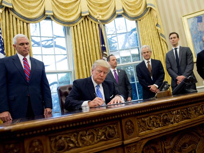 US President Donald Trump signing an executive order alongside White House Chief of Staff Reince Priebus, US Vice President Mike Pence, National Trade Council Advisor Peter Navarro, Senior Advisor Jared Kushner and Senior Policy Advisor Stephen Miller in the Oval Office. Picture: AFP