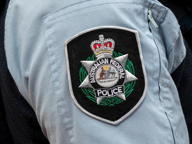 Insignia badge on the shirt of a policeman of the Australian Federal Police standing on the street outside Admiralty House, Kirribilli Avenue, Kirribilli on the northern shore of Sydney Harbour. Admiralty House is the residence of the Governor-General and Monarch when in Sydney. This image was taken on a bright and overcast afternoon on 19 October 2024.