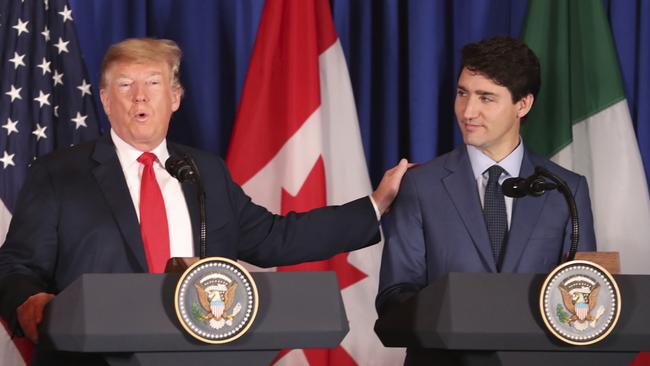 President Donald Trump touches the shoulder of Canada's Prime Minister Justin Trudeau as they prepare to sign a new United States-Mexico-Canada Agreement that is replacing the NAFTA trade deal, during a ceremony at a hotel before the start of the G20 summit in Buenos Aires, Argentina, Friday, Nov. 30, 2018.The USMCA, as Trump refers to it, must still be approved by lawmakers in all three countries. (AP Photo/Martin Mejia)