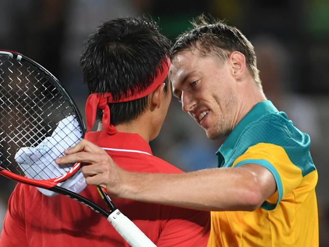 Japan's Kei Nishikori (L) speaks to Australia's John Millman after winning their men's second round singles tennis match against at the Olympic Tennis Centre of the Rio 2016 Olympic Games in Rio de Janeiro on August 8, 2016. / AFP PHOTO / Roberto SCHMIDT