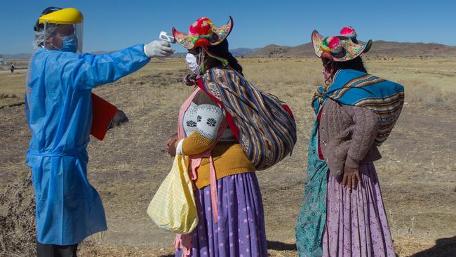 A Peruvian health worker checks temperatures at a market in Coata, near the border with Bolivia on Wednesday. Picture: AFP