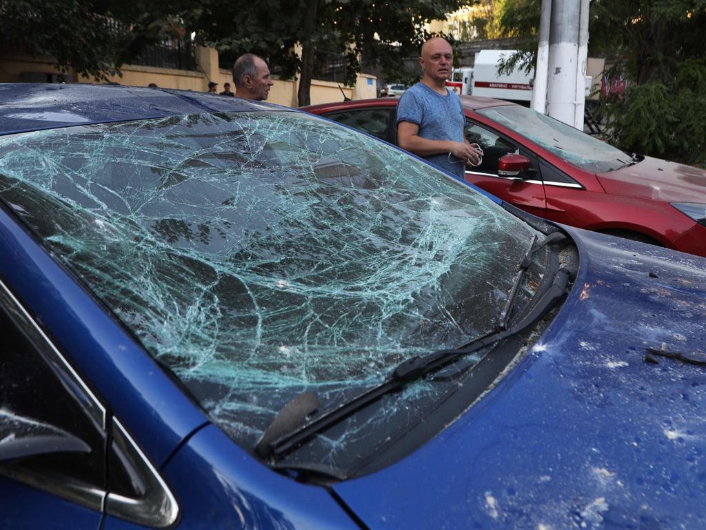 Local residents walk past damaged cars following a missile strike in Odessa amid the Russian invasion of Ukraine. Picture: AFP