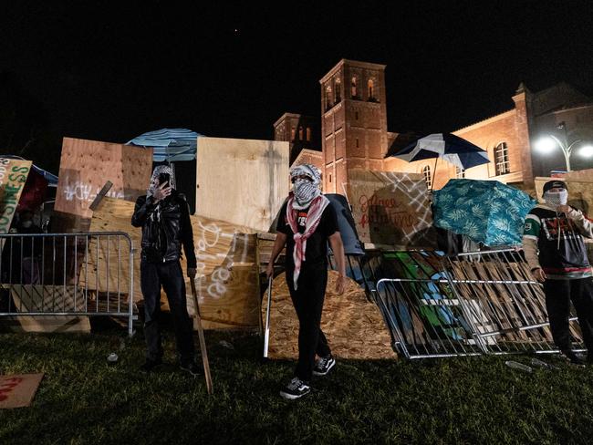 Pro-Palestinian demonstrators regroup and rebuild the barricade surrounding the encampment set up on the campus of the University of California Los Angeles. Picture: AFP