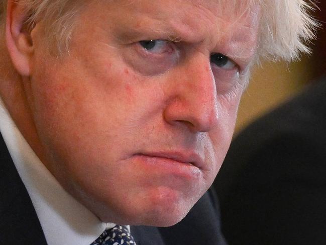 (FILES) In this file photo taken on May 24, 2022 Britain's then prime minister Boris Johnson adjusts his tie at the start of a cabinet meeting at 10 Downing Street in London. Johnson announced his resignation as an MP on June 9, 2023, accusing a parliamentary probe into the 