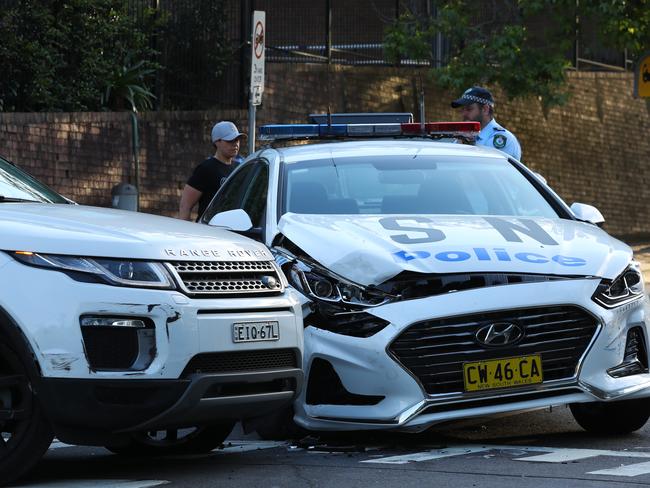 Crashed police cars on Jenkins st Chatswood after a pursuit with a white Range Rover . Another police van down the road has taken out a 40 km zone sign . No police were injured and one person is in custody .picture John Grainger