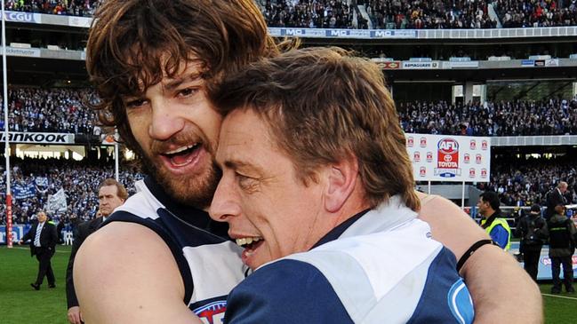 Max Rooke and former Geelong coach Mark Thompson hug after the grand final win.