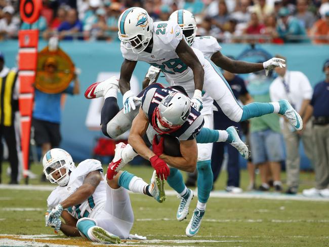 Julian Edelman #11 of the New England Patriots is brought down by Will Davis #29 of the Miami Dolphins in the second quarter.