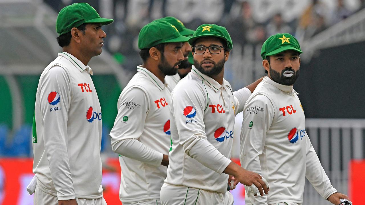 Pakistan's players walk back to the pavilion after the third day play was stopped due to bad light during the first Test cricket match between Pakistan and Australia at the Rawalpindi Cricket Stadium in Rawalpindi on March 6, 2022. (Photo by Aamir QURESHI / AFP)