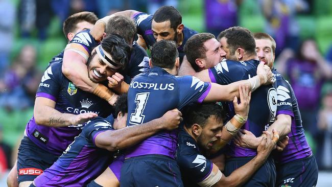 Kenny Bromwich is congratulated by teammates after scoring a try.