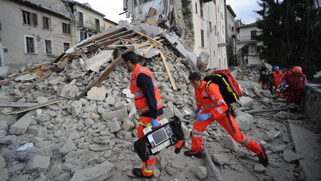 Rescuers search a crumbled building in Arcuata del Tronto, central Italy, where a 6.1 earthquake struck. Picture: Sandro Perozzi.