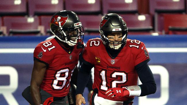 Quarterback Tom Brady #12 of the Tampa Bay Buccaneers congratulates wide receiver Antonio Brown #81 after a touchdown during the 1st quarter of the game against the Washington Football Team at FedExField on January 09, 2021 in Landover, Maryland. (Photo by Patrick Smith/Getty Images)