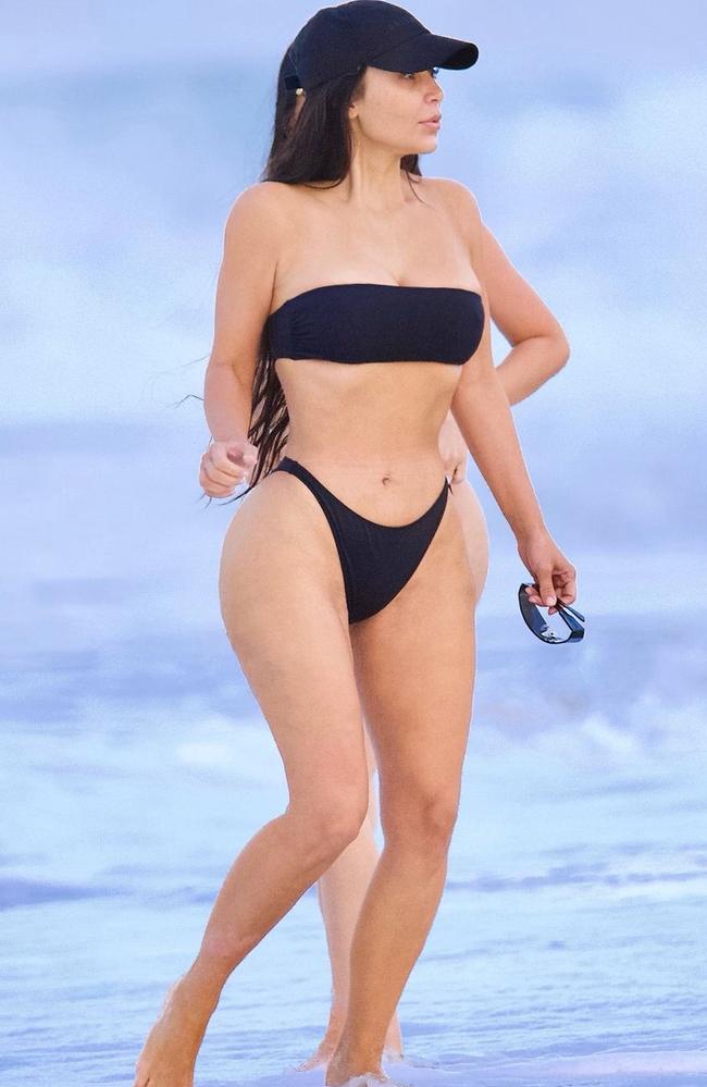 Kim flaunted her figure in the all-black beach look. Picture: Diggzy/Shutterstock