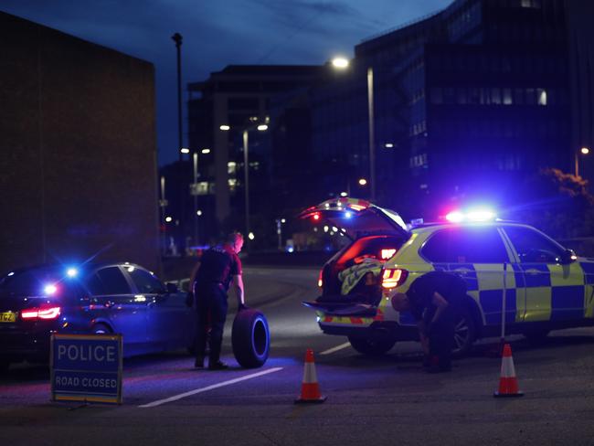 Police officers change the tyre of a vehicle at the police cordon near Forbury Gardens park in Reading, west of London, following a stabbing incident. Picture: Adrian Dennis/AFP