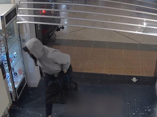 Police are looking for a couple who drove to the top floor of Tweed City shopping centre, smashed windows and drove through glass sliding doors before making a dash for it with stolen jewellery.