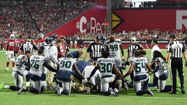 Members of the Seattle Seahawks kneel while trainers tend to defensive back Earl Thomas. Picture: Getty Images