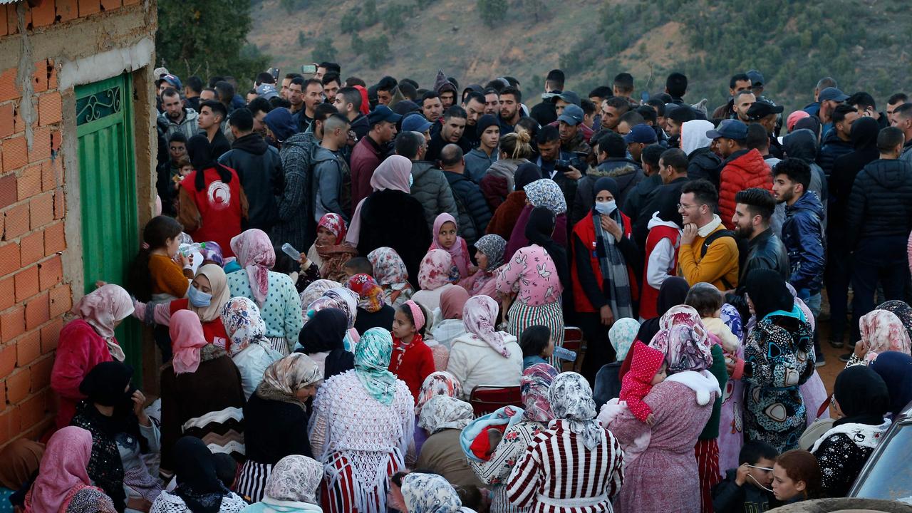 People gather as Moroccan civil defence members (unseen) work to rescue five-year-old child Rayan trapped in a deep well for over two days in the Northern Province of Chefchaouen near Bab Berred on February 3, 2022. (Photo by AFP)