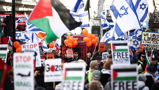 Protesters wave Israel flags and hold placards during a rally called by pro-Israel non-profit organisation Stop the hate as they gather in front of a pro-Palestinian march calling for an end to Israel’s siege of Gaza. Picture: Henry Nicholls / AFP