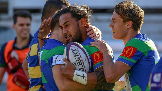 GPS player Davis Tavita is surrounded by teammates.