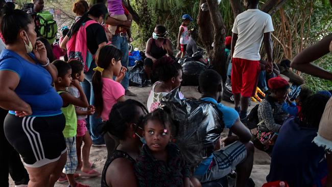 Migrants, many of them Haitian, sit on the banks of the Rio Grande river before crossing the Mexico-US border last month. Picture: AFP