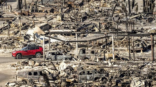 A car drives past homes and vehicles destroyed by the Palisades Fire at the Pacific Palisades Bowl Mobile Estates. Picture: AP