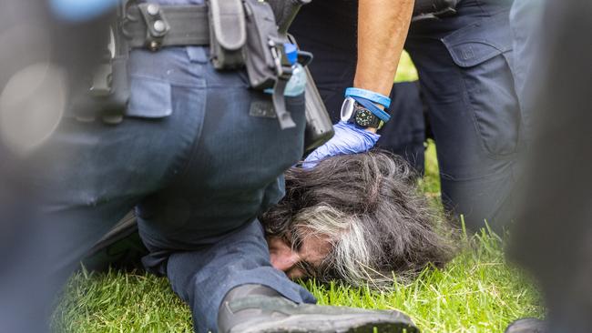 Anti-vaxxers protest against COVID-19 vaccinations at Fawkner Park in Melbourne on Saturday. Police arrest a protester at Fawkner Park. Picture: Jake Nowakowski