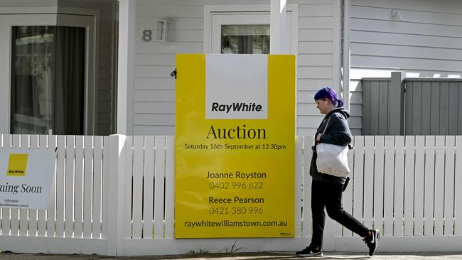 A woman walks past an auction sign outside a house in Melbourne on September 5, 2023 as the Reserve Bank of Australia (RBA) prepares to make it's monthly monetary policy decision on interest rates. (Photo by William WEST / AFP)