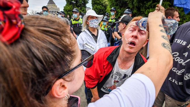 A protester rinses their face after police use capsicum spray. Picture: Jake Nowakowski