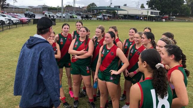 The Sandgate girls listen to an address from their coach Shane Watterson.