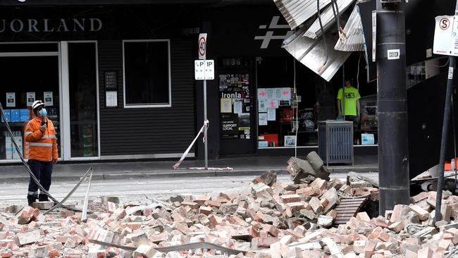 Inspecting a damaged building in Melbourne’s Chapel Street. Picture: AFP