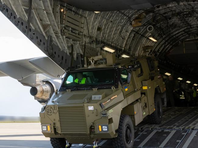 An Australian Army Bushmaster Protected Mobility Vehicle is unloaded from a Royal Australian Air Force C-17A Globemaster III at a European airport for forward movement to Ukraine.  (This image has been digitally altered for operational security purposes) *** Local Caption *** The Australian Government has provided further support to the Government of Ukraine by gifting 20 Bushmaster Protected Mobility Vehicles, including two ambulance variants, to aid the Government of Ukraineâs response to Russiaâs unrelenting and illegal aggression.  Australiaâs response follows a direct request from President Zelenskyy during his address to a joint sitting of the Parliament of Australia on 31 March 2022.  The Bushmaster Protected Mobility Vehicle was built in Australia to provide protected mobility transport, safely moving soldiers to a battle area prior to dismounting for close combat. The Bushmaster Protected Mobility Vehicle is well suited to provide protection to the Ukrainian Armed Forces soldiers and Ukrainian civilians against mines and improvised explosive devices, shrapnel from artillery and small arms fire.  The 20 vehicles have been painted olive green to suit the operating environment. Additionally, a Ukrainian flag is painted on either side with the words âUnited with Ukraineâ stencilled in English and Ukrainian to acknowledge our commitment and support to the Government and people of Ukraine. The ambulances will have the traditional red cross emblem.  The Bushmaster Protected Mobility Vehicles will be fitted with radios, a global positioning system and additional bolt-on armour increasing their protection.