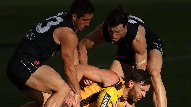 Blues pair Jacob Weitering and Lachie Plowman tackle Hawks forward Jack Gunston. Picture: Getty Images