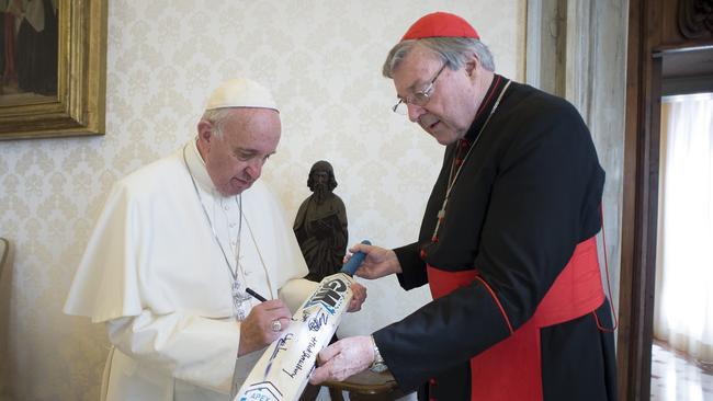Pope Francis signs a cricket bat of Canterbury cricket team received from Cardinal George Pell at the Vatican. He remained true to Australian values of mateship and loyalty, his friends say.