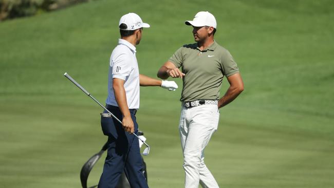 Jason Day bumps fists with Xander Schauffele on the second hole as he withdraws from the tournament due to a neck injury Picture: Jeff Gross/Getty Images