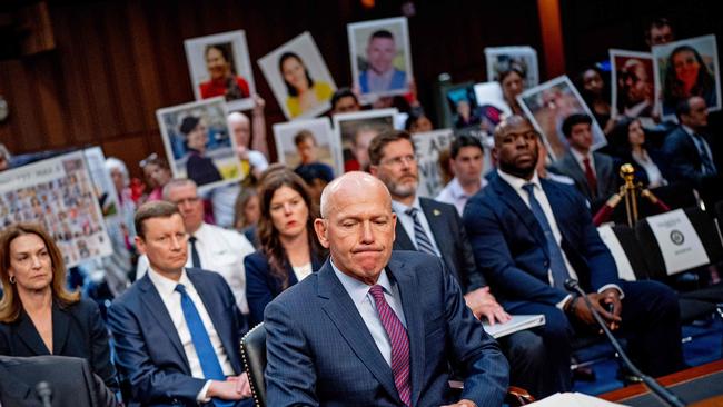 Family members of those killed in the Ethiopian Airlines Flight 302 and Lion Air Flight 610 crashes hold photographs of their loved ones as Boeing CEO Dave Calhoun arrives for a hearing on June 18. Picture: Getty