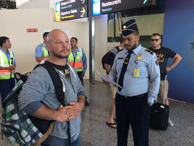 Ricky Longmuir (left) and Michael Matthews (at right) are escorted onto the plane. Picture: Supplied