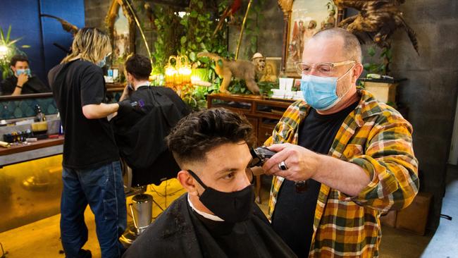 Craig Kershaw, owner of the Dr Follicles barber shop in Richmond, gives local James Kechris a long-overdue haircut on Monday. Picture: Paul Jeffers