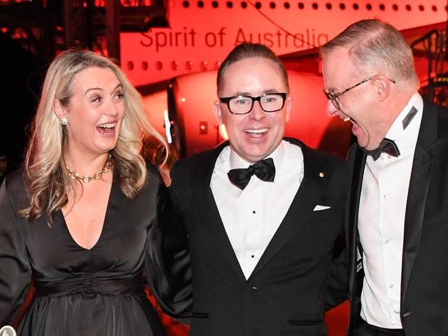 Alan Joyce, Anthony Albanese and his partner Jodie Haydon share a joke at the Qantas 100th Gala Dinner in 2023. Picture: James D. Morgan/Getty Images