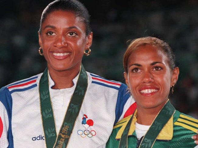 France's gold medalist in the women's 400 final, Marie-Jose Perec (C) stands on the podium at presentation ceremony with fellow medalists, Nigeria's Falilat Ogunkoya, bronze (L) and Australia's Cathy Freeman, silver, at 1996 Atlanta Olympic Games. 29/07/96. /Athletics /Olympic Games