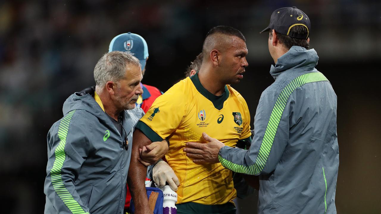 Kurtley Beale of Australia is assisted off the pitch by medical staff.