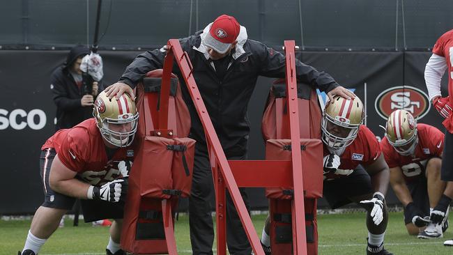 San Francisco 49ers offensive line coach Pat Flaherty, centre, talks with Blake Muir, left, and Norman Price while practising during an NFL football rookie minicamp.